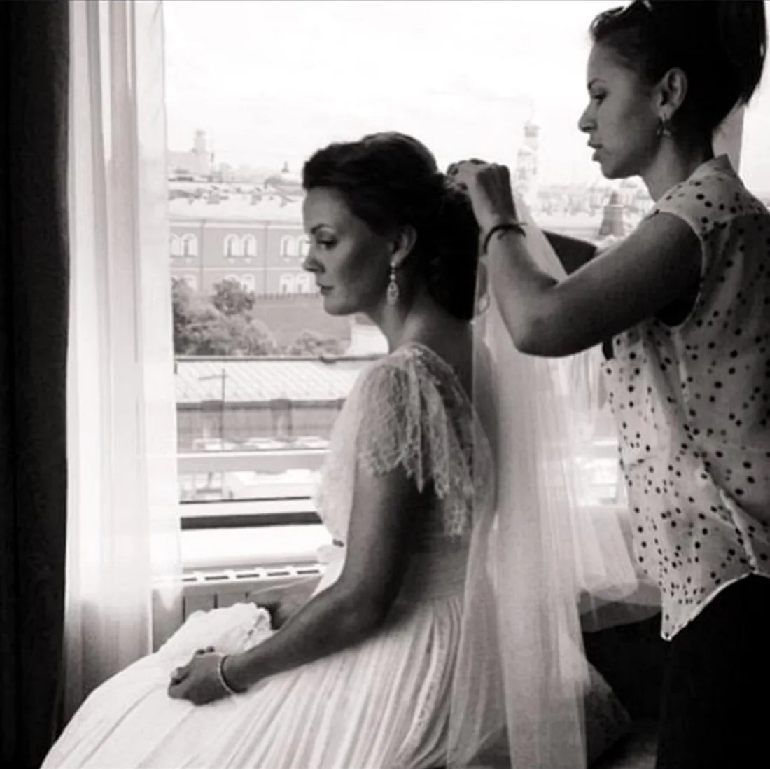 Aida finishing a bride's hair by the window
